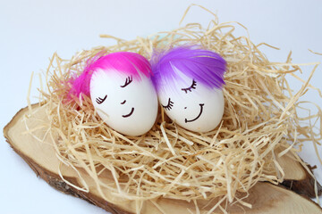 Two eggs with trendy hairstyles. Close-up. Cheerful playful easter. Selective focus.