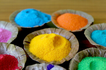 Indian Holi  traditional colors in disposal organic bowl, different organic Gulal color on the occasion of Holi festival, Abstract background, selective focus with blur.
