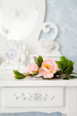 Obraz na płótnie Canvas Tender tea rose on beautiful white dressing table
