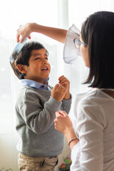 Fototapeta premium A woman combing a small child's hair