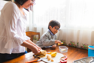 A woman and a child prepare fruit in the morning