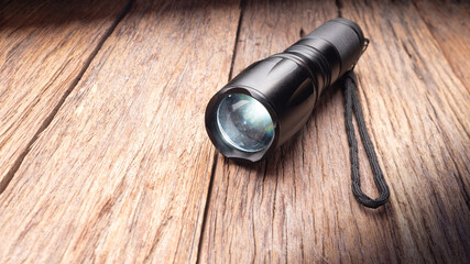 black metal flashlight on wooden floor - 423330834