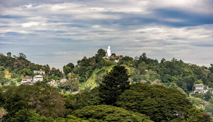 Mountain view of the city pond and buildings of Kandy city against the overcast sky in Sri Lanka