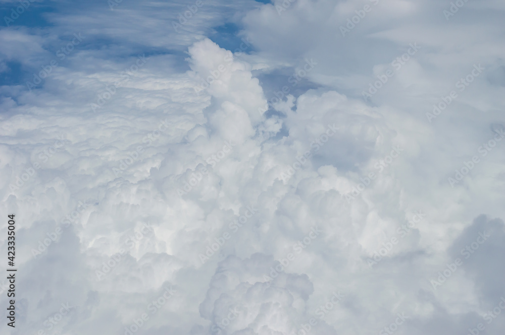Wall mural over the clouds,blue sky with tiny clouds background beautiful natural view from airplane window abo