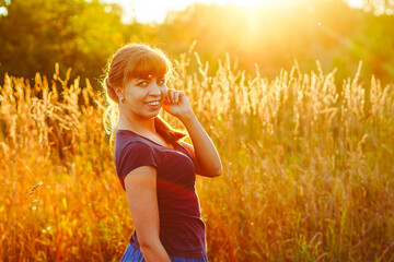 beautiful girl in the grass at sunset