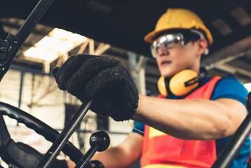 Skillful worker drives forklift in the factory . Industrial people and manufacturing labor concept .