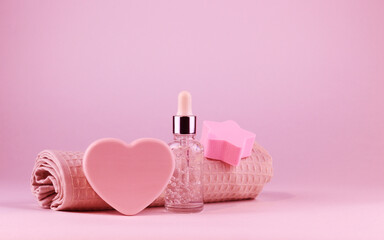 Face serum bottle, natural heart-shaped soap and rose towel. The concept of natural organic products and caring for your skin