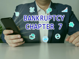  BANKRUPTCY CHAPTER 7 inscription on the screen. male hands holding black smart phone.