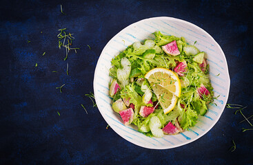 Salad from watermelon radish, cucumber, celery and lettuce leaves. Vegan food. Dietary menu. Top view, overhead, copy space