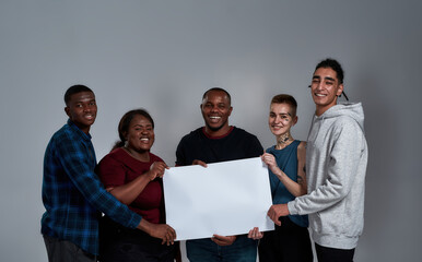Happy young multiracial people holding empty placard