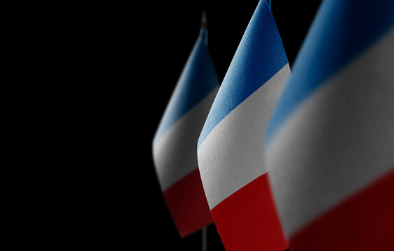 Small national flags of the France on a black background