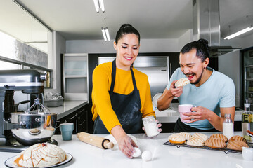 latin couple bakers preparing dough for baking mexican bread called Conchas in kitchen in Mexico city