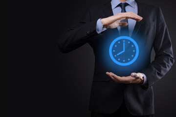 Businessman hand holds the icon of hours clock with arrow. Rapid execution of the work.Business...