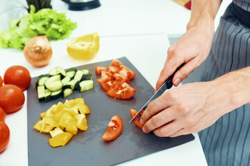 diced vegetables on a kitchen board indoors and the hands of a professional chef
