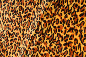 Colored brown textile satin fabric folded in folds and waves with highlights and texture