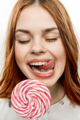 pretty red-haired woman eating lollipop enjoyment emotion close-up