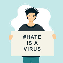 Stop Asian Hate‬‬. Hashtag to support asian community during the covid-19 pandemic. Stop racism. Man wearing protective face mask and holding banner against bullying, hate and violence.

