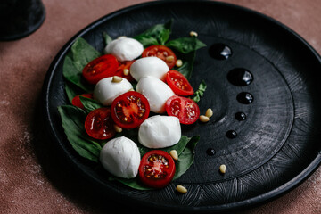 caprese salad on a black plate