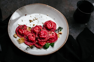 beet ravioli in a light plate on a dark background