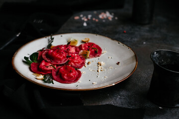 beet ravioli in a light plate on a dark background