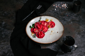 beet ravioli in a light plate on a dark background