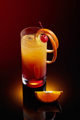 Cocktail tequila sunrise on a black reflective background.