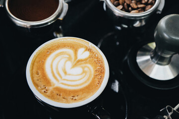 A portafilter with coffee beans, a portafilter with ground coffee, an espresso shot and an empty cup of hot cappuccino cup