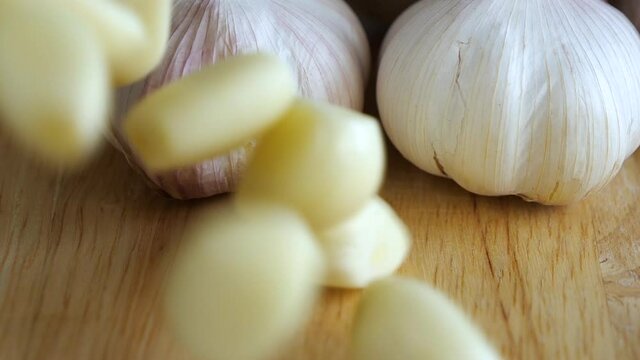 Top view slow motion of pouring garlic on wooden table
