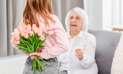 Grandaughter gives flowers to grandmother