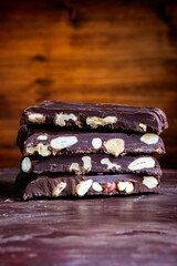 Organic food snack tasty sweet dessert milk dark chocolate bar macro closeup broken slide piece and fruit orange raspberry hazelnut nuts on cocoa cacao powder wooden table for new year Christmas gift