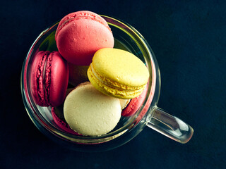 Sweet Macaron of different colors on an darke background