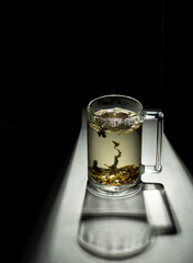 transparent mug with tea on a black background