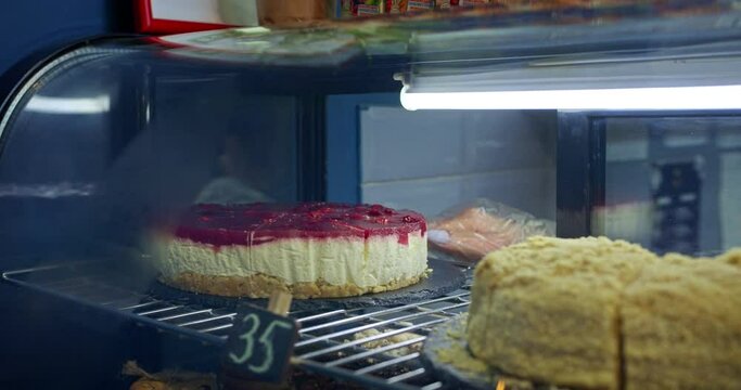 the girl's hands put the cake on the showcase