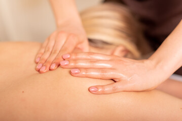 Obraz na płótnie Canvas Close up photo of deep tissue massage. Masseuse doing shoulder and back massage. Client lying and relaxing
