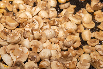 fresh mini mushrooms champignons chopped fried in a pan
