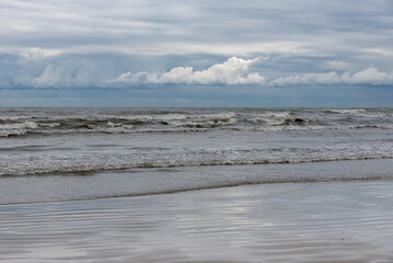 Winter seashore with clouds and waves