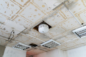 Disassembled plasterboard office ceiling with fire protection system