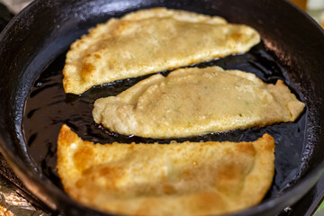 cheburek fried in a pan with a golden crust traditional baking of Tatarstan