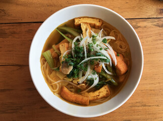bowl of vietnamese soup with a wood background