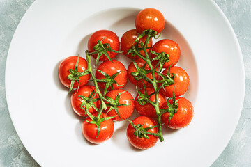 Fresh ripe red tomatoes on white plate with marble background.Top view.Rustic food photography.