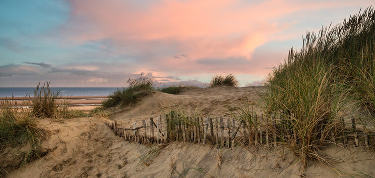 Beautiful sunrise over sand dunes system on yellow sand golden beach