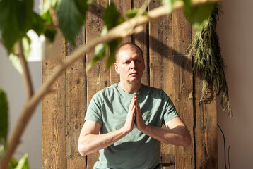 Mature man meditating, practicing yoga and meditation with plants with daylight