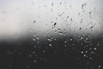 Raindrops on glass embodying sadness and grief in black and white