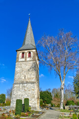 Fototapeta na wymiar Kirchturm auf einem Friedhof in Gruiten Dorf