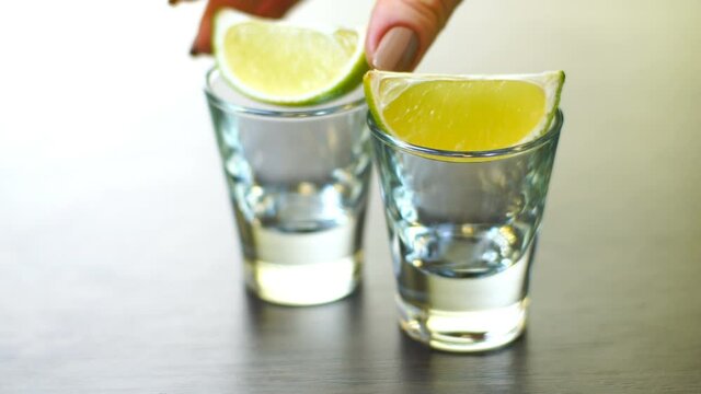 strong alcohol pouring into shot glasses on white background