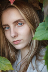 Naklejka premium natural caucasian pretty lady with blue eyes posing in autumn bush foliage