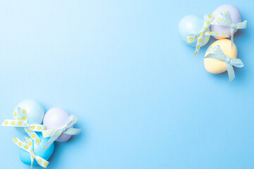 Easter border. Colorful egg with tape ribbon on pastel blue background in Happy Easter decoration. Flat lay, top view.