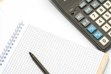 calculator and fountain pen on a white sheet of paper