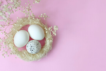 Easter photo with eggs in a nest on a pink background. Preparation for the Easter holiday.