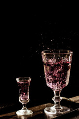 Berry drink. Dark photography. Front of the glass in focus.